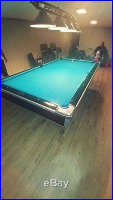 9 foot Brunswick slate pool table with ball return. New bumpers and felt